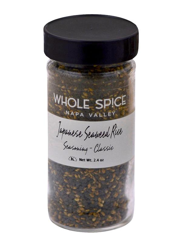 A clear spice jar from Whole Spice Inc. labeled Japanese RiceSeaweed Seasoning - Classic, filled with a flavorful blend of sesame seeds and dried seaweed, net weight 2.4 oz, features a black lid.
