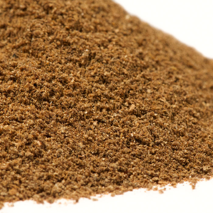 Close-up of Lemon Omani White Ground by Whole Spice Inc., a finely ground spice made from dried Omani lemons, used as a souring agent in Middle Eastern cuisine, shown on a white background.