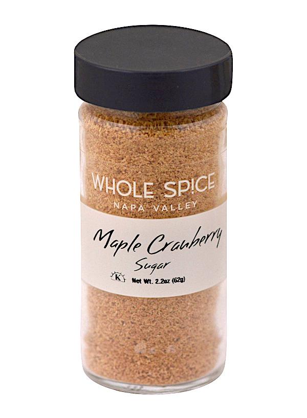 Whole Spice Inc. Maple Cranberry Sugar comes in a clear 2.2 oz (62g) glass jar with a black lid, filled with light brown gourmet sugar—ideal for holiday baking.