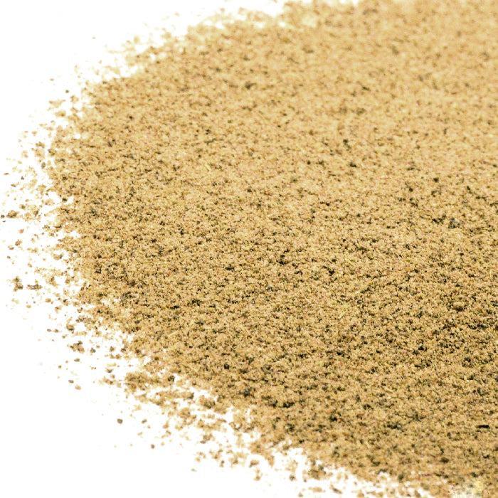 A close-up of Mecalef Egyptian Mix by Whole Spice Inc., a finely ground peppery-floral blend ideal for enhancing chicken and vegetable dishes, spread across a white surface.