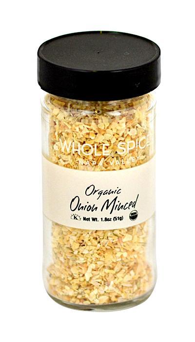 A clear glass jar with a black lid contains Whole Spice Inc. Onion Minced Organic, dried minced onion, and features a white label. Net Wt. 1.8 oz (51g).