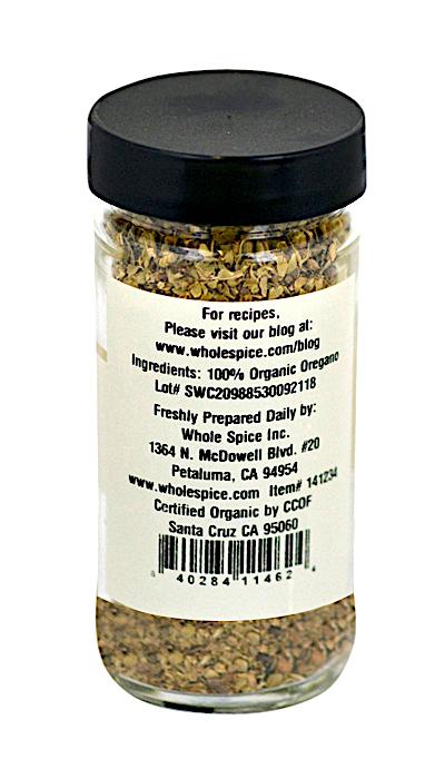 Oregano Organic by Whole Spice Inc. comes in a clear glass jar with a black lid, filled with 100% organic oregano. The back label features company details, an address in Petaluma, CA, and their website for recipes.