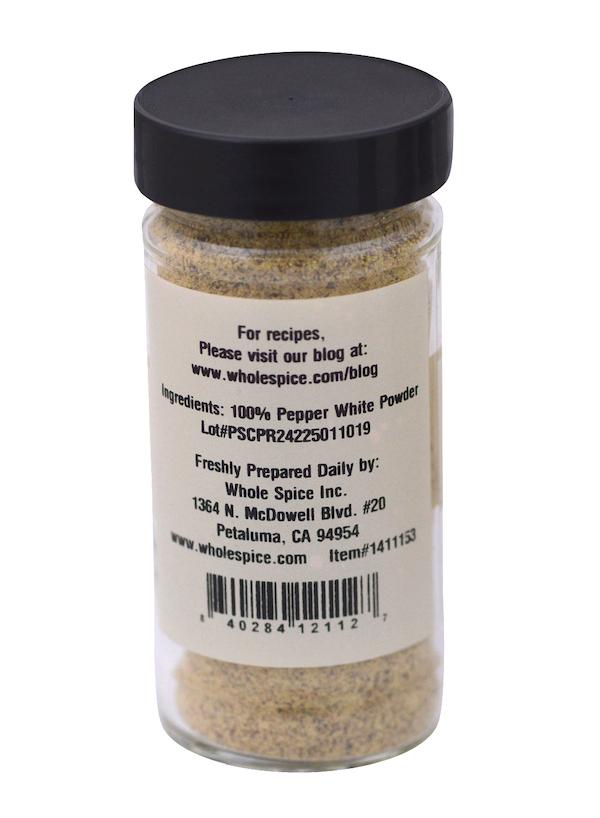 A clear jar with a black lid labeled "Pepper White Powder" by Whole Spice Inc., listing 100% ground white peppercorns—ideal for white sauces—plus prep info, website, and barcode.