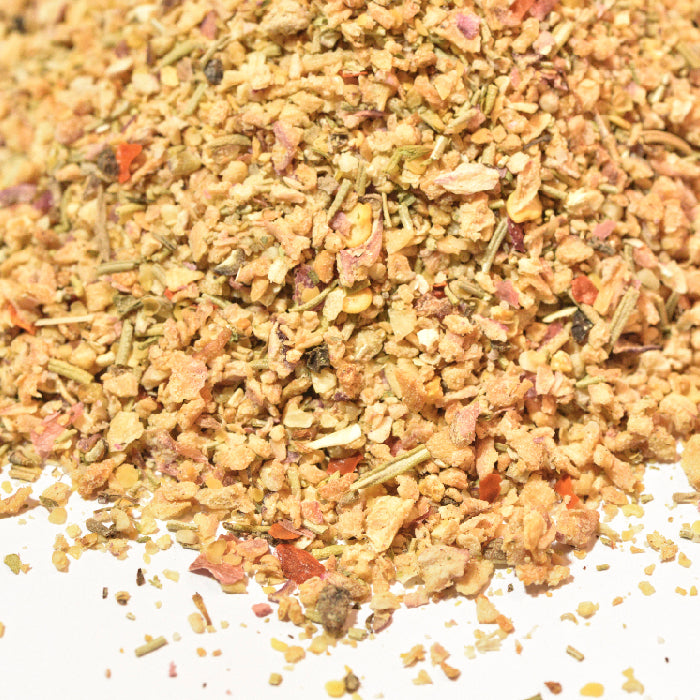 A pile of spices, including rosemary and Whole Spice Inc. Roast Lamb Rub, sits on a white surface.
