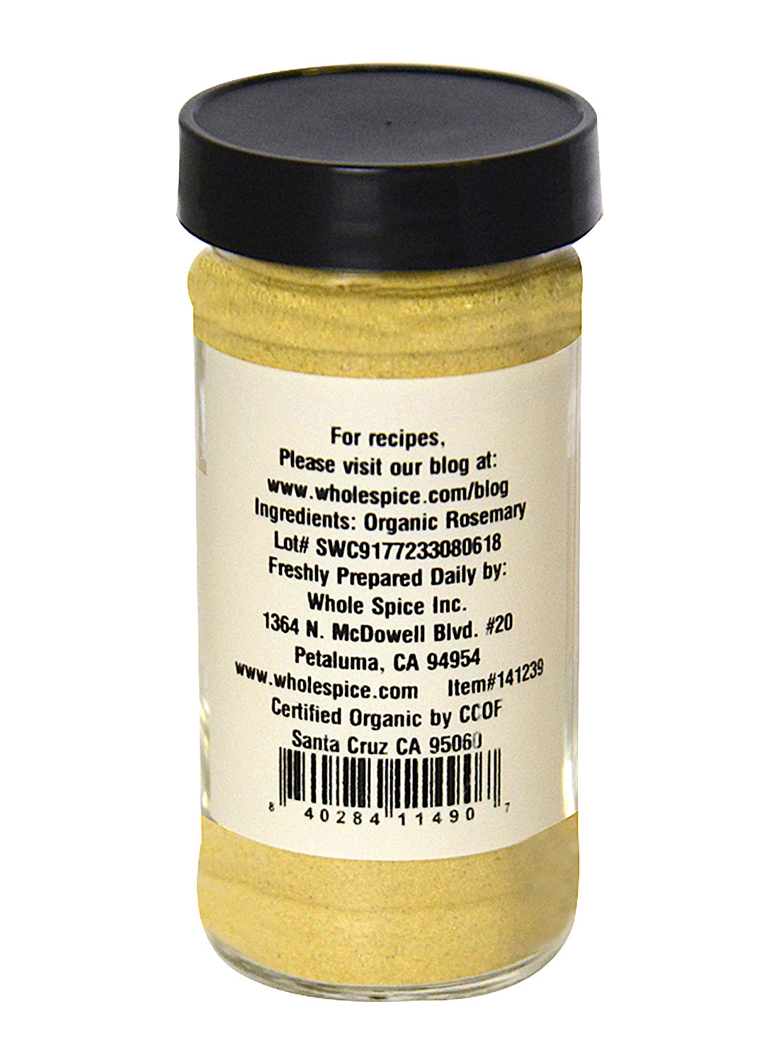 A clear jar with a black lid contains light yellow Rosemary Powder Organic by Whole Spice Inc. The label lists organic rosemary, preparation address, certification details, and a website for Mediterranean herb recipes.