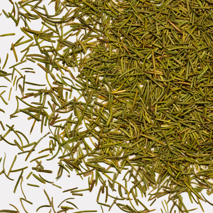 Rosemary by Whole Spice Inc., a classic Mediterranean herb, is shown as dried leaves scattered on a white background, with some aromatic pieces spread outward from the main pile.