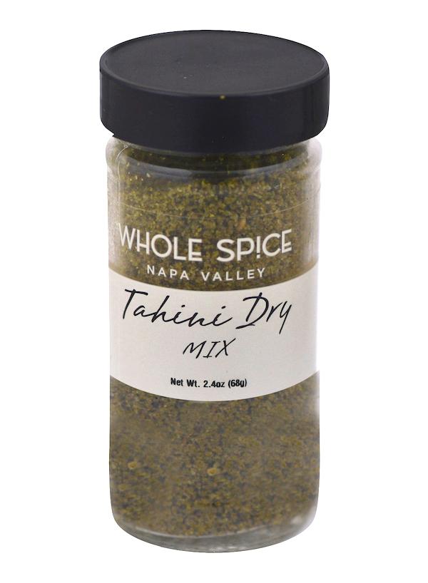 A clear spice jar with a black lid labeled Whole Spice Inc. Tahini Dry Mix, Net Wt. 2.4oz (68g), contains a coarse greenish-brown blend—ideal for homemade tahini or enhancing your favorite recipes.