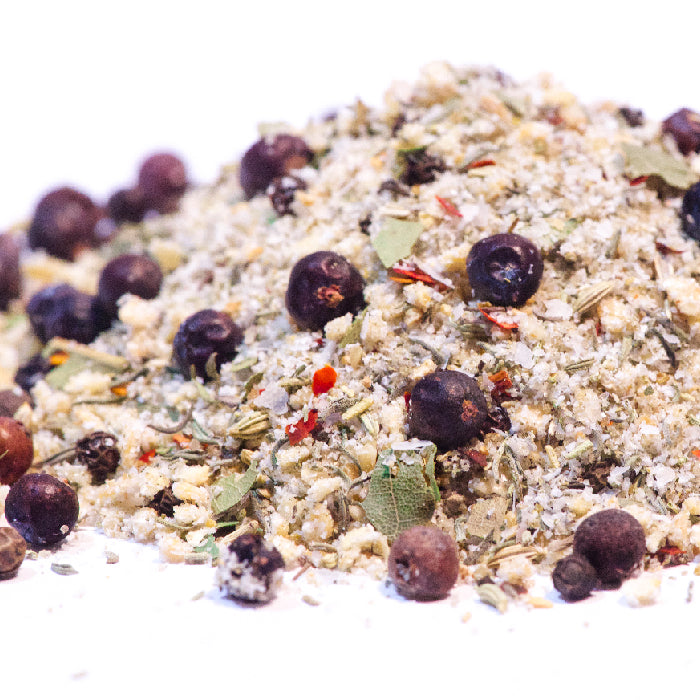 A close-up of Whole Spice Inc.'s Turkey Brining Blend—coarse salt, dried herbs, red pepper flakes, and whole dried berries—perfect for seasoning your next turkey brine, all displayed on a white background.