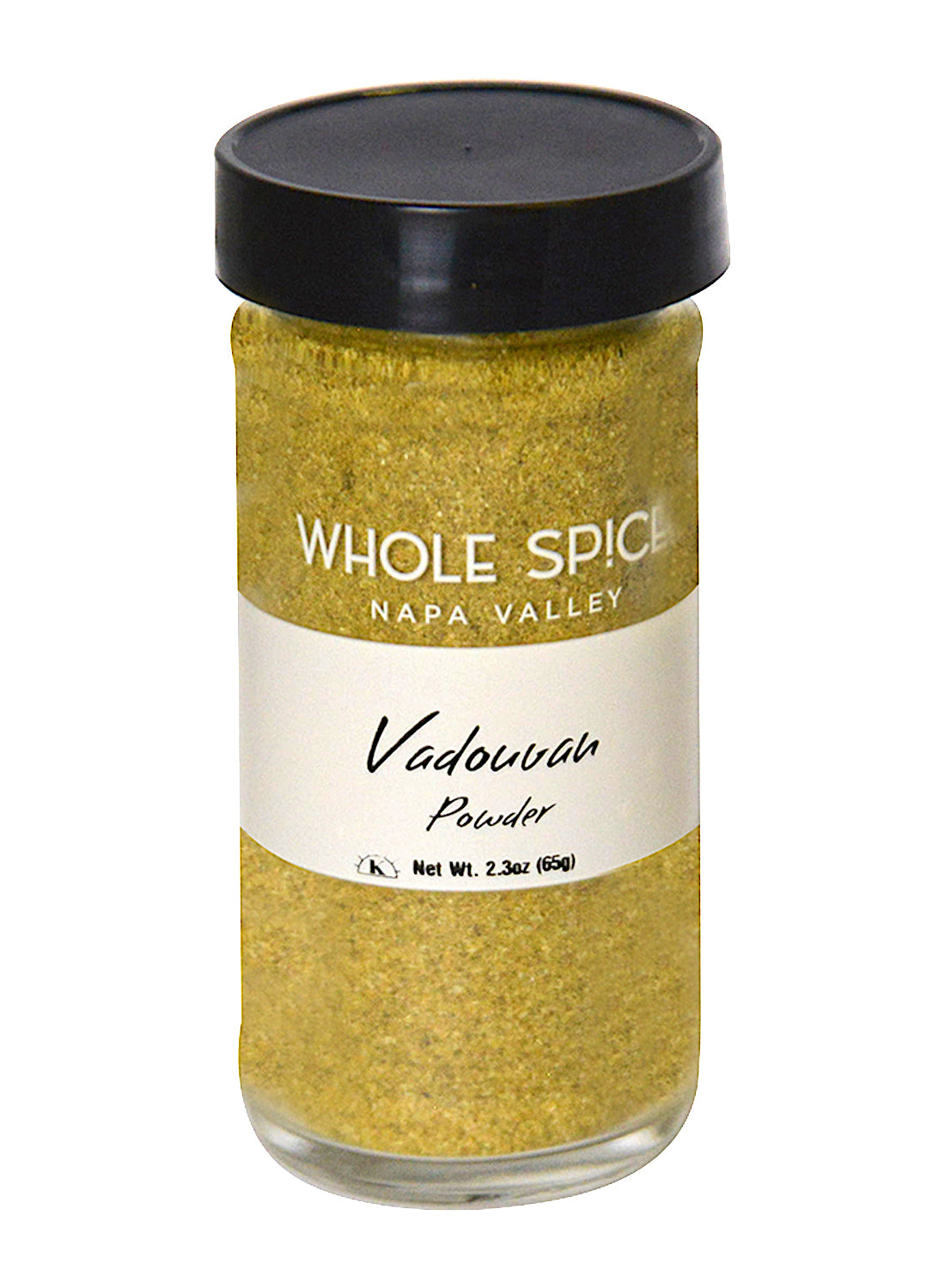 A glass jar with a black lid labeled Whole Spice Inc. Vadouvan Powder contains 2.3 oz (65g) of a yellowish curry blend inspired by Indian spices and French flavors.