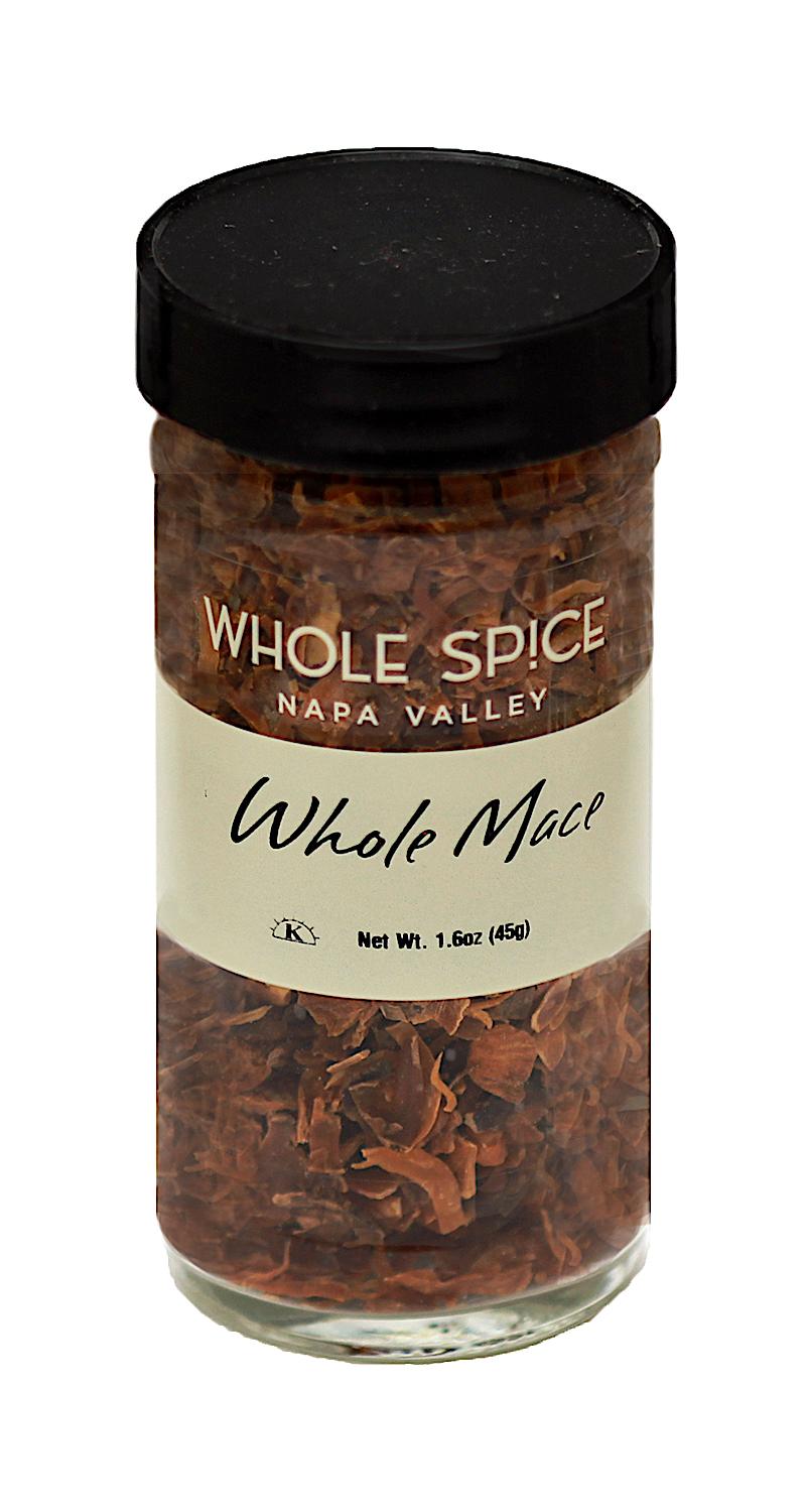 A clear glass jar with a black lid labeled Whole Spice Inc. Mace Whole contains dried brown mace spice pieces, often used in French cuisine. Net weight: 1.6 oz (45g).