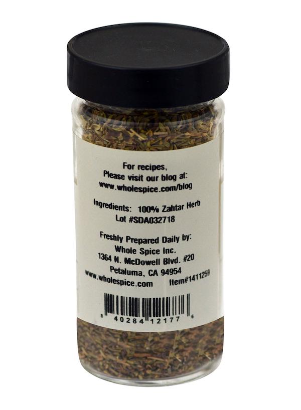 A clear spice jar with a black lid contains Whole Spice Inc.'s Za'atar Herb, labeled as 100% zaatar herb. The label includes contact and location information for Whole Spice Inc. in Petaluma, California.